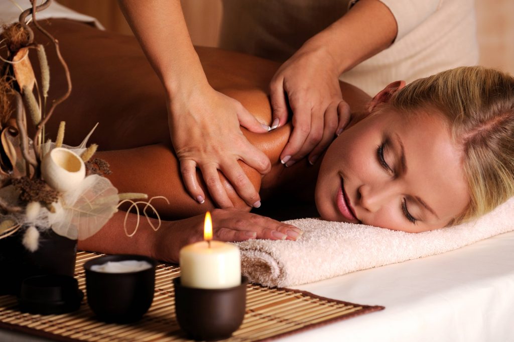 masajista realizando masaje en la espalda a mujer en un spa
