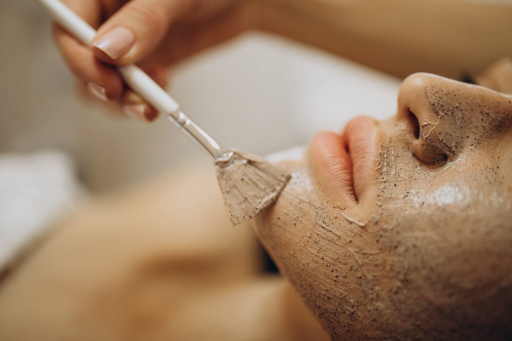 mujer recibiendo tratamiento facial con mascarilla